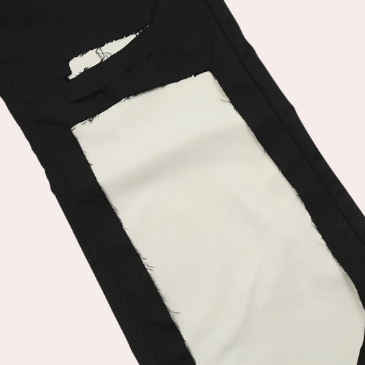 Schwarze Jeans mit weißem, rechteckigem Riss-Detail, modische zerrissene Denim-Hose.