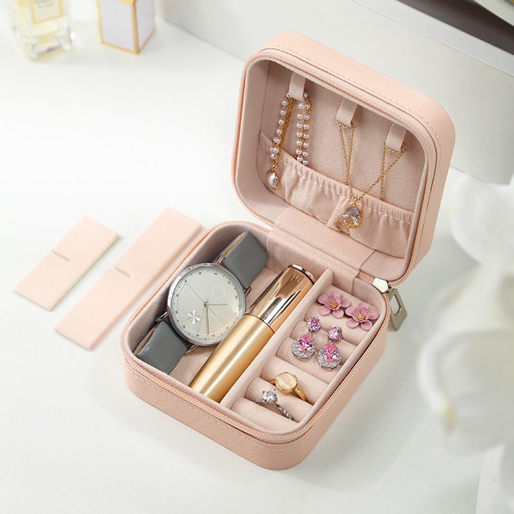Rosa Schmuckbox mit Uhr, Ohrringen, Ringen und Lippenstift, ideal für Reisen und Aufbewahrung.