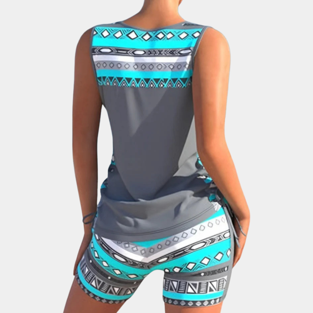 Frau in grauem Tankini mit blauem Aztekenmuster, Sommermode, Bademode, Rückansicht.