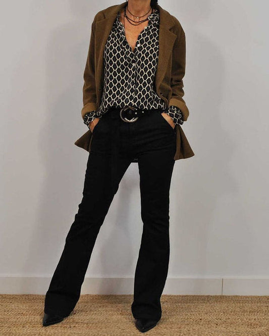Frau in braunem Blazer, gemusterter Bluse und schwarzer Hose, modisches Outfit, Herbstmode.