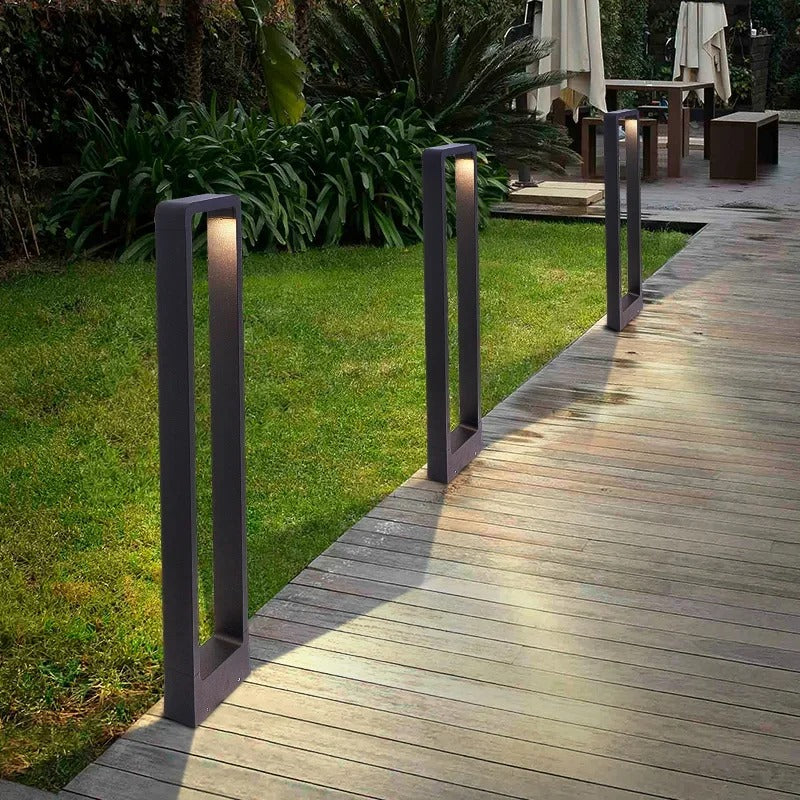 Moderne schwarze Gartenleuchten aus Metall beleuchten Holzweg im Außenbereich.