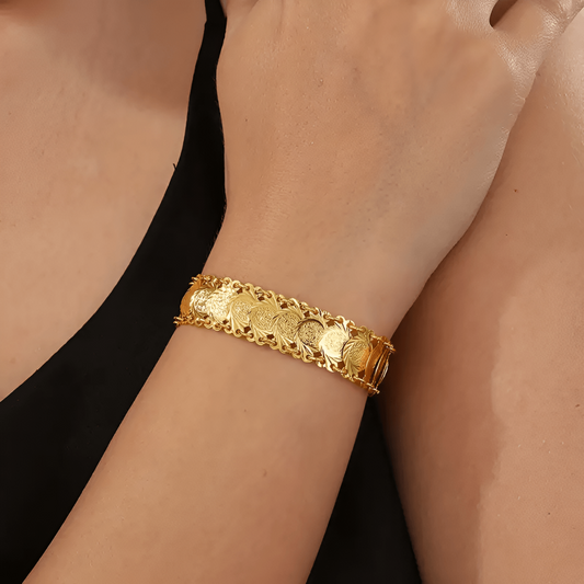 Goldenes Armband mit Münzdesign, Damenmode, eleganter Schmuck, luxuriöses Accessoire.