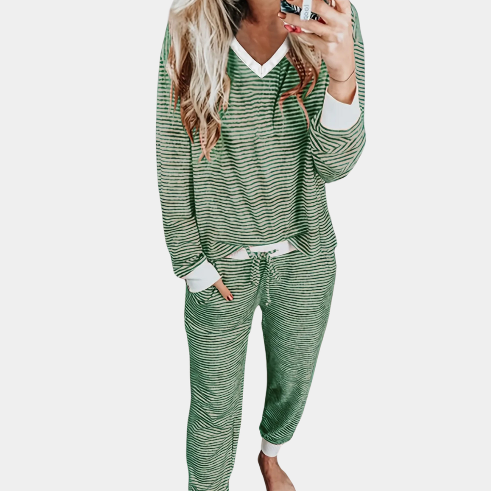 Frau in grün-weiß gestreiftem Pyjama, Langarmshirt und Hose, gemütliche Nachtwäsche.