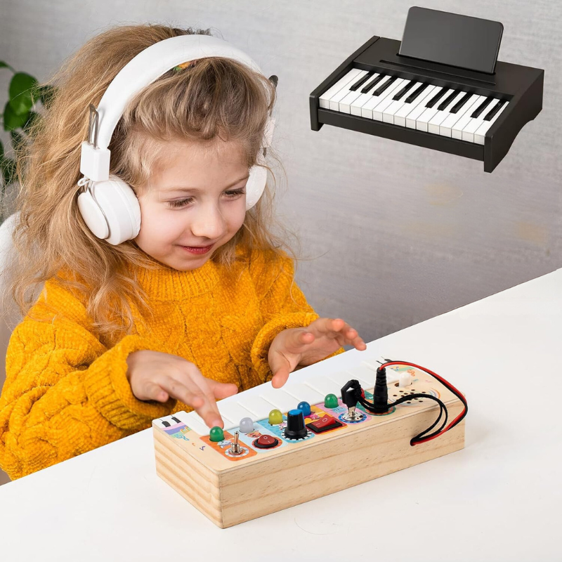 Mädchen mit gelbem Pullover spielt mit elektronischem Musikspielzeug, Kopfhörer tragend.