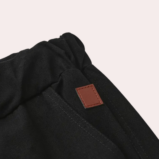 Schwarze Jogginghose aus Baumwolle mit elastischem Bund und braunem Lederetikett.