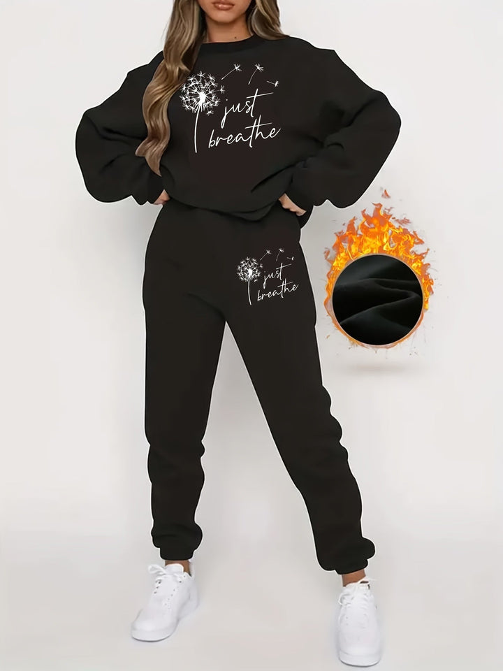 Frau in schwarzem Jogginganzug mit "Just Breathe"-Aufdruck, weiße Sneaker, gemütliche Mode.