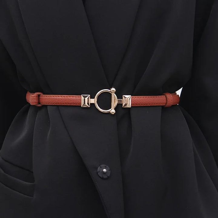 Brauner Ledergürtel mit goldener Schnalle, Damenmode, elegantes Accessoire, schwarzer Mantel.