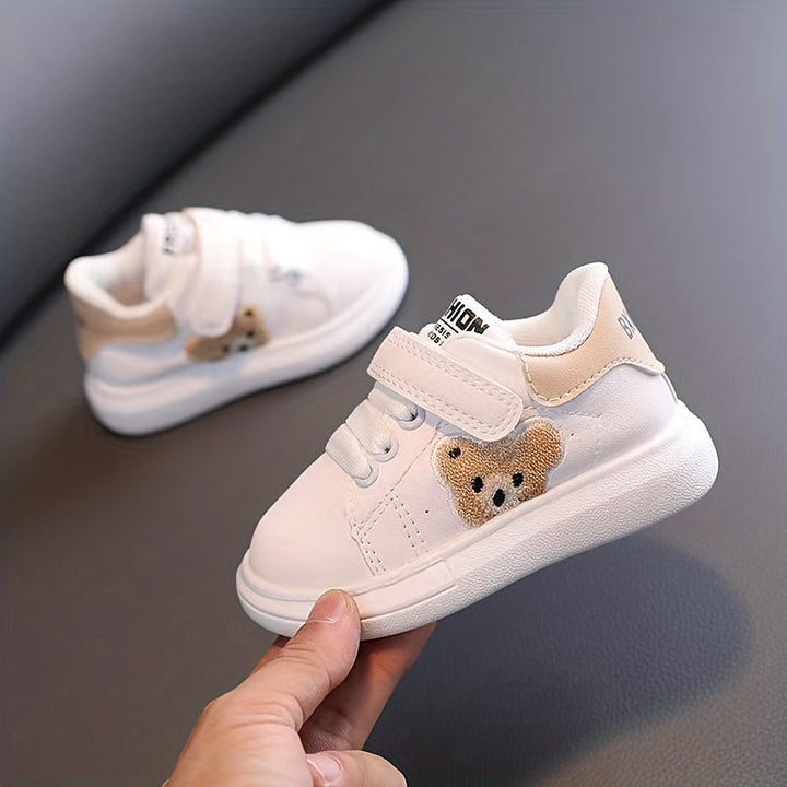 Weiße Kinderschuhe mit Bärenmotiv, Klettverschluss, rutschfeste Sohle, modisch, bequem.
