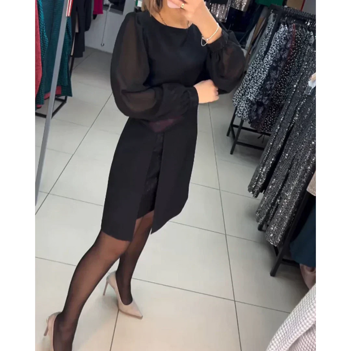 Frau in schwarzem Kleid mit langen Ärmeln, trägt schwarze Strumpfhose und beige Pumps im Modegeschäft.