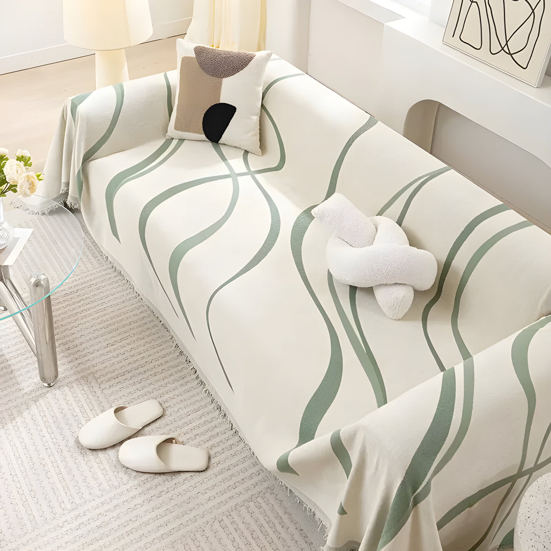 Beigefarbene Couch mit grünem Wellenmuster, dekoriert mit Kissen, im modernen Wohnzimmer.
