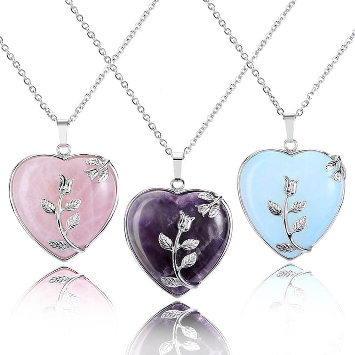 Drei herzförmige Anhänger aus Rosenquarz, Amethyst, Opal mit Silberkette und Blumenmotiv.