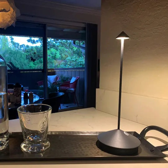 Moderne schwarze Tischlampe auf Küchentheke, LED-Beleuchtung, minimalistisches Design.