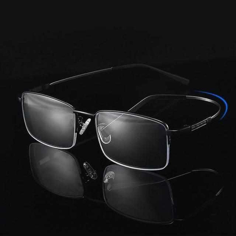 Schwarze rechteckige Brille mit Metallrahmen auf schwarzem Hintergrund.