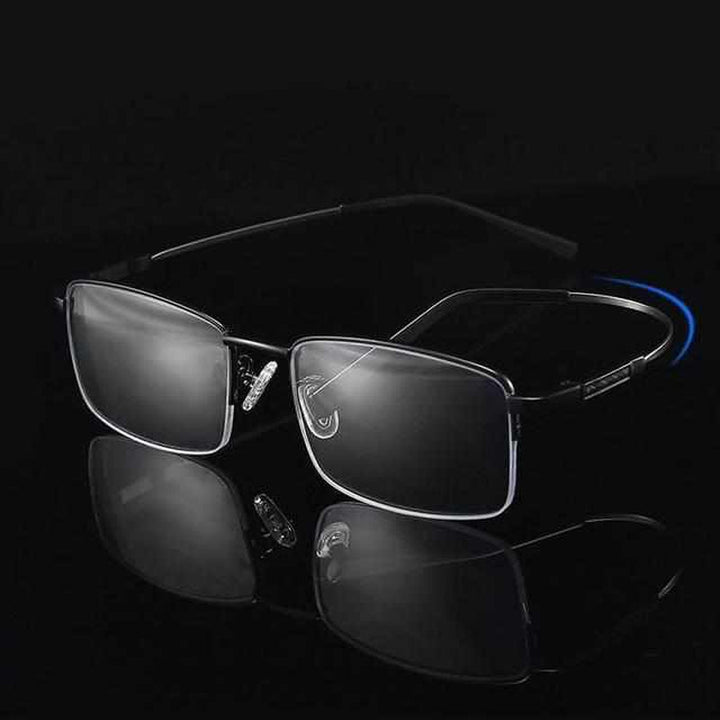 Schwarze rechteckige Brille mit Metallrahmen auf schwarzem Hintergrund.