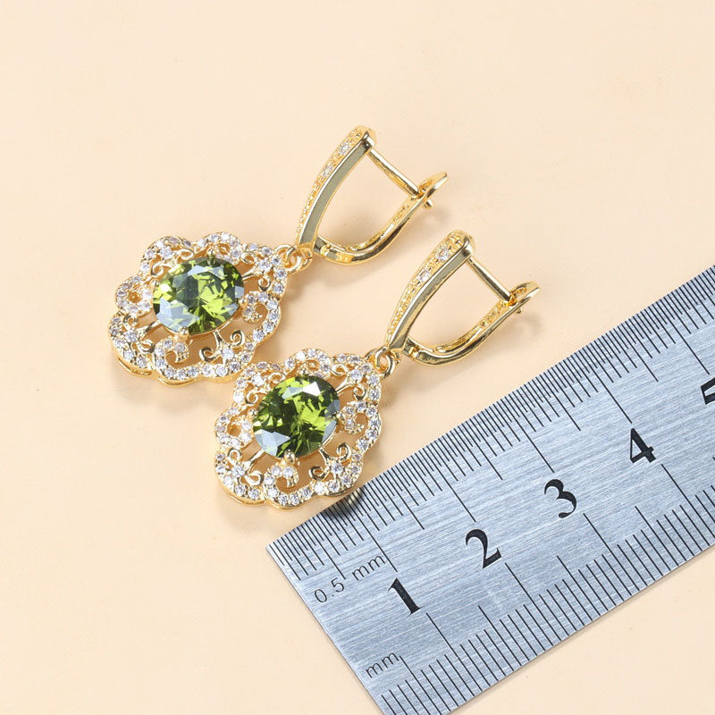 Goldene Ohrringe mit olivgrünen Zirkonia, Schmuck, Damenaccessoires, funkelnd, elegant.