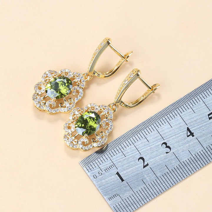 Goldene Ohrringe mit olivgrünen Zirkonia, Schmuck, Damenaccessoires, funkelnd, elegant.