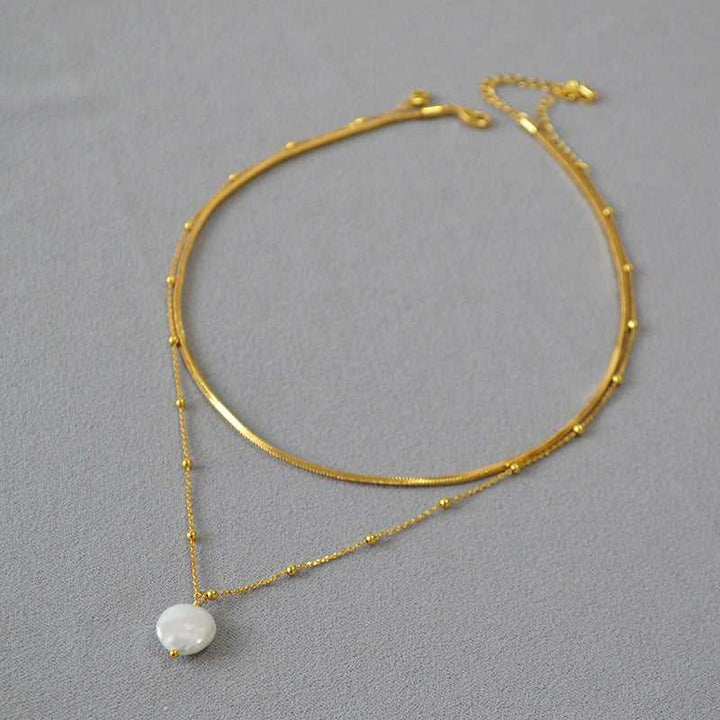 Goldene Halskette mit Perlenanhänger, elegantes Schmuckdesign, Damenmode Accessoire.