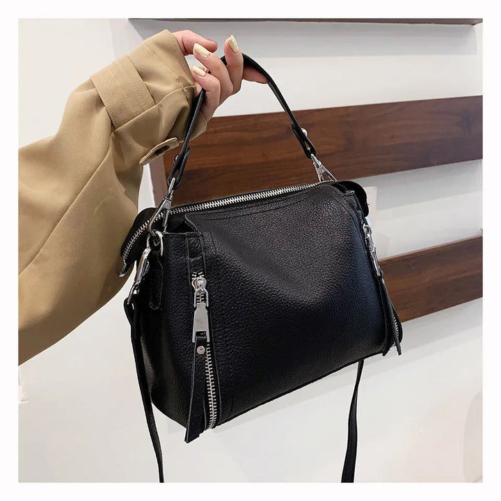 Schwarze Lederhandtasche mit Reißverschlüssen, Damenmode, elegantes Accessoire.