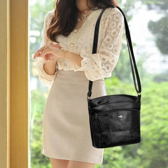Frau mit schwarzer Ledertasche, Spitzenbluse, beiger Rock, stilvoll, elegant, Modeaccessoire.