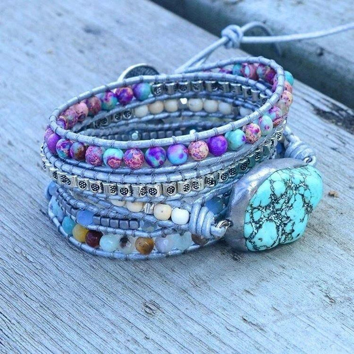 Mehrfarbiges Armband mit Türkisstein, handgefertigt, Boho-Stil, auf Holztisch.