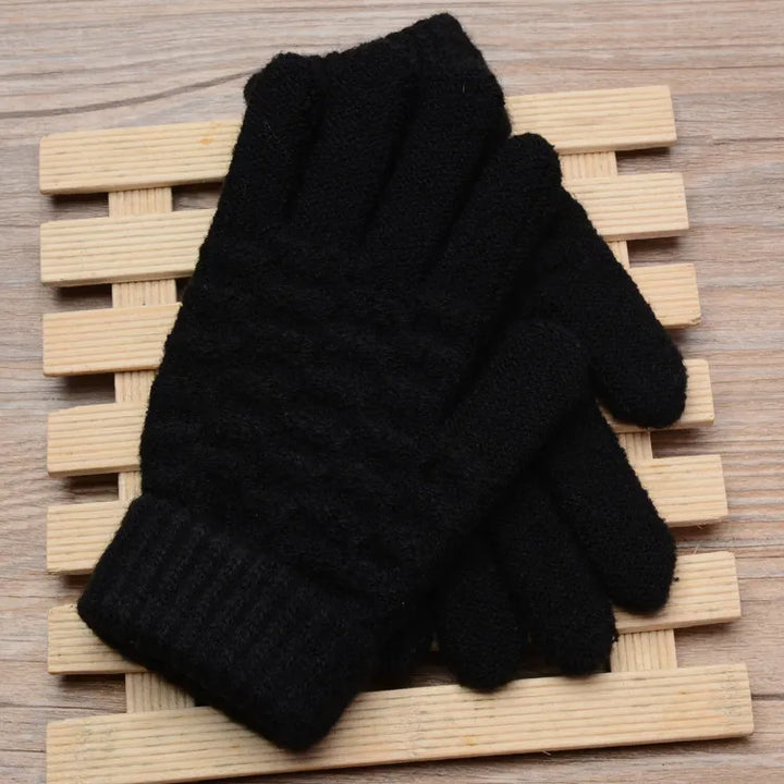Schwarze Strickhandschuhe auf Holzunterlage, warm, wintertauglich, modisch, unisex.
