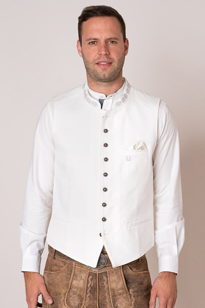 Mann in weißer Trachtenweste und Lederhose, traditionelles bayerisches Outfit.