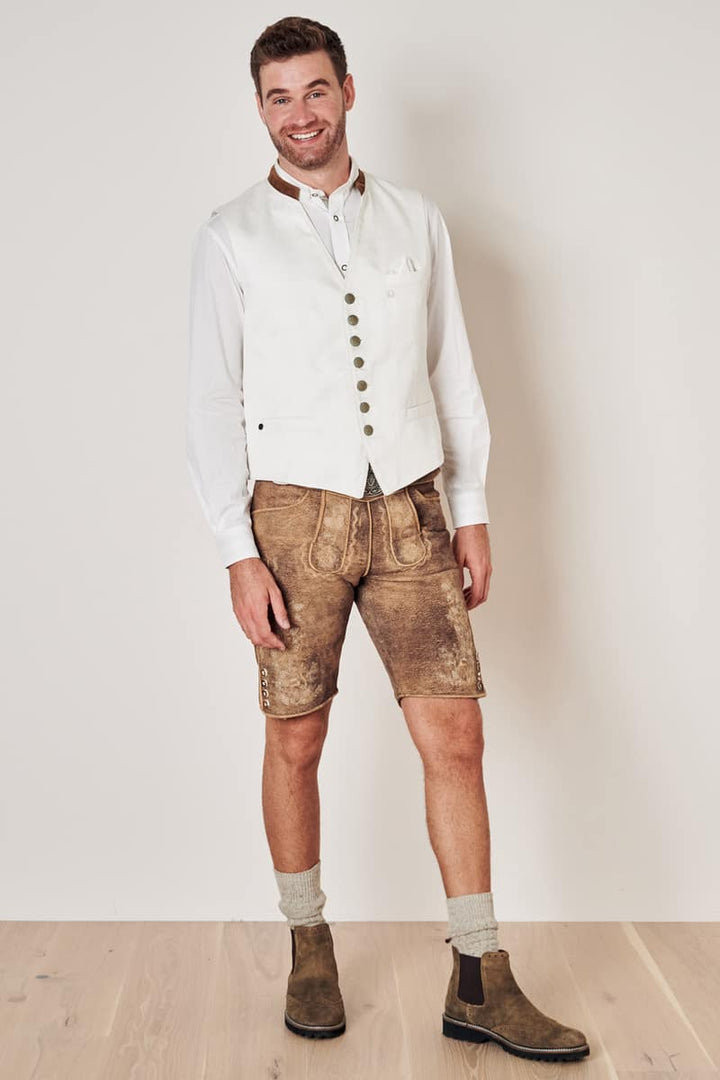 Mann in weißer Weste und brauner Lederhose, traditionelles bayerisches Outfit, Trachtenmode.