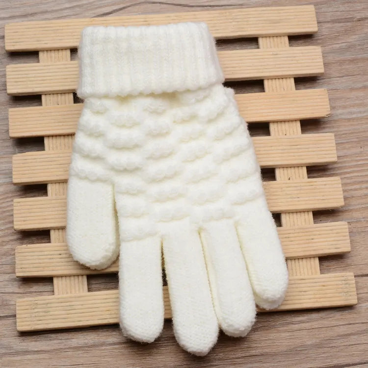 Weiße gestrickte Wollhandschuhe auf Holzunterlage, Wintermode Accessoire.