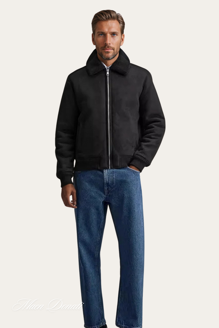 Schwarze Herrenjacke mit Reißverschluss, Stehkragen, kombiniert mit blauer Jeans.