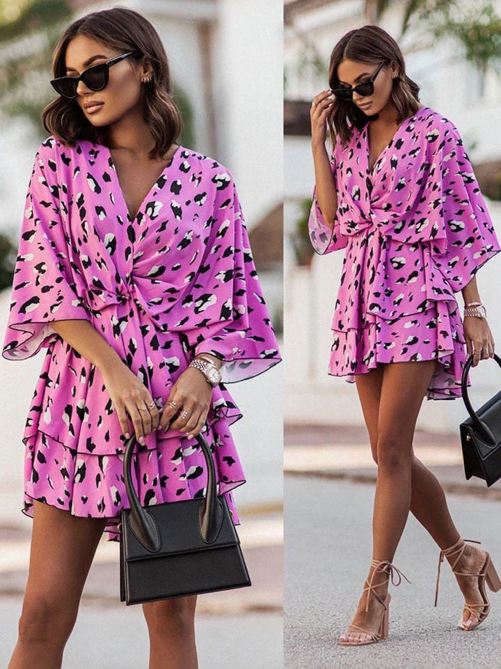 Frau in rosa Leopardenkleid mit Sonnenbrille und schwarzer Handtasche, modisch, Sommeroutfit.