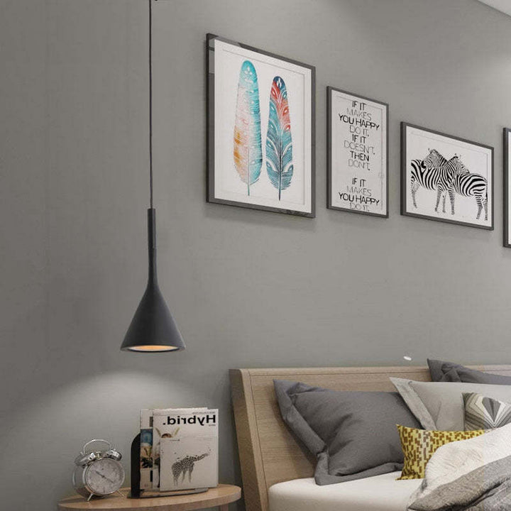 Moderne schwarze Pendelleuchte im Schlafzimmer, graue Wand, Bilderrahmen, minimalistisches Design.