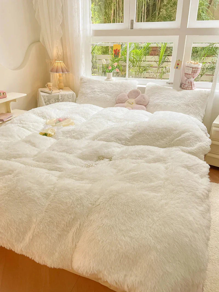 Gemütliches Schlafzimmer mit weißem, flauschigem Bettbezug, Kissen und Dekorationen.