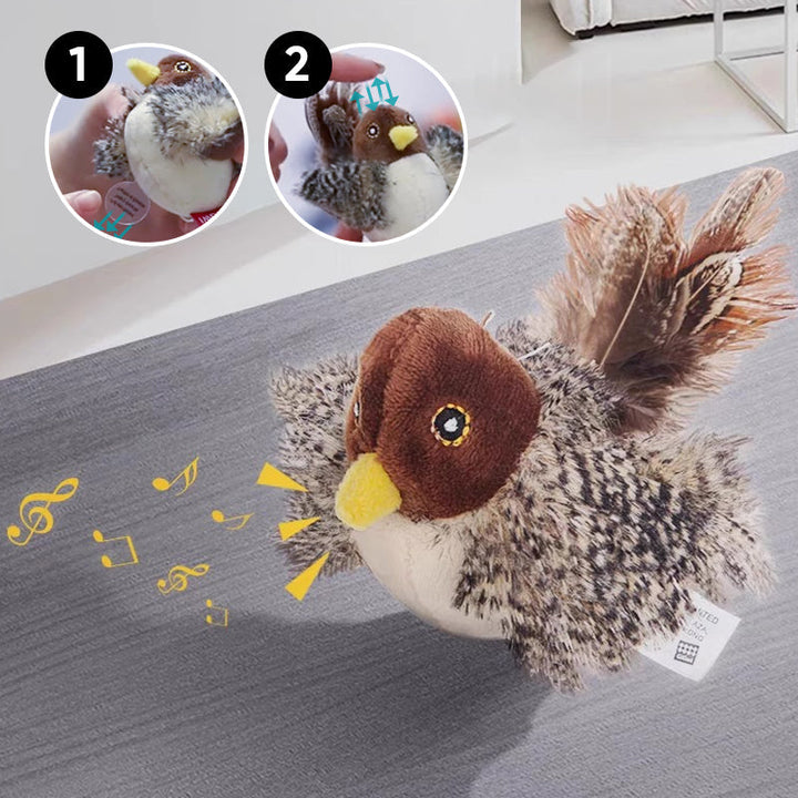 Plüschvogel mit braunem Kopf und gelbem Schnabel, singend, auf grauem Teppich.