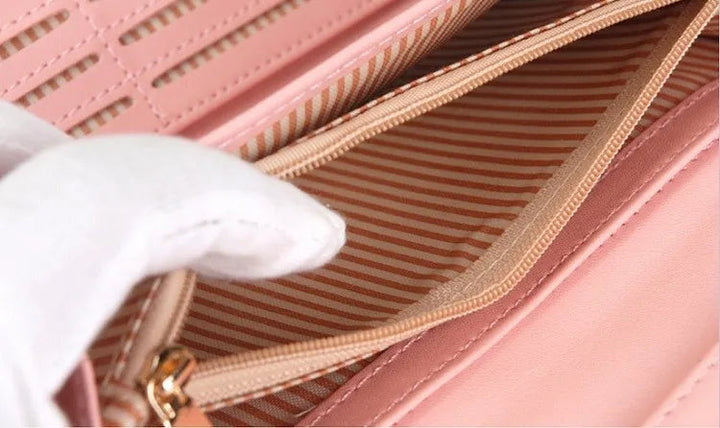 Rosa Damenhandtasche mit gestreiftem Innenfutter, Reißverschluss, elegantes Design.