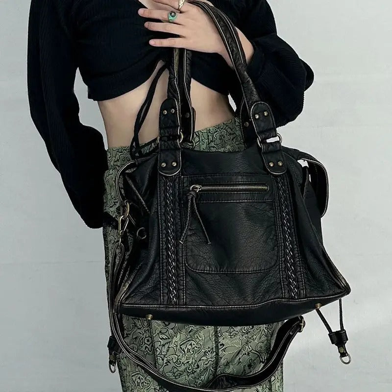 Frau mit schwarzer Lederhandtasche, modisch, elegant, Damenaccessoire, Vintage-Stil.