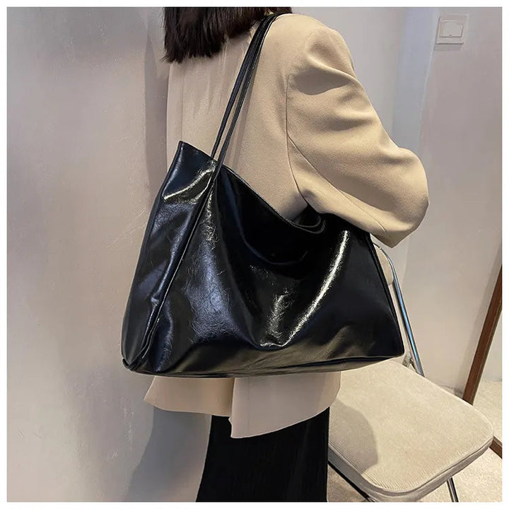 Schwarze Lederhandtasche, Damen, elegant, groß, modisch, über der Schulter getragen.