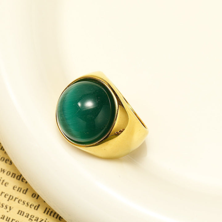 Goldener Ring mit grünem Edelstein, elegantes Schmuckdesign, luxuriöses Accessoire.