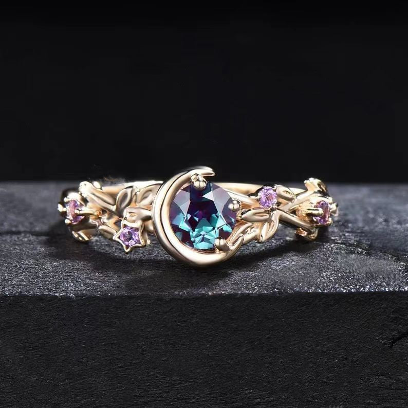 Goldring mit blauem Edelstein und lila Akzenten, filigranes Design, Schmuck für Damen.
