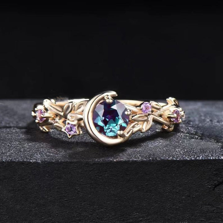 Goldring mit blauem Edelstein und lila Akzenten, filigranes Design, Schmuck für Damen.