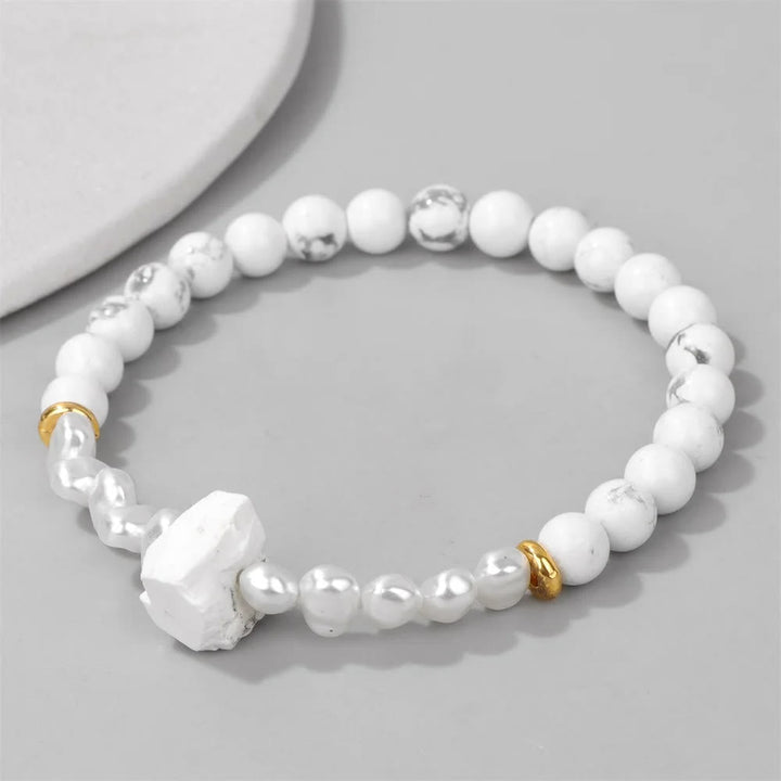 Weiße Perlenarmband mit goldenen Akzenten, Howlith und Süßwasserperlen, elegantes Schmuckdesign.
