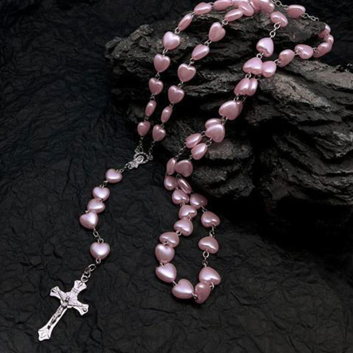 Rosenkranz mit rosa Perlen, Herzform, silbernes Kreuz, religiöses Schmuckstück, Gebet.