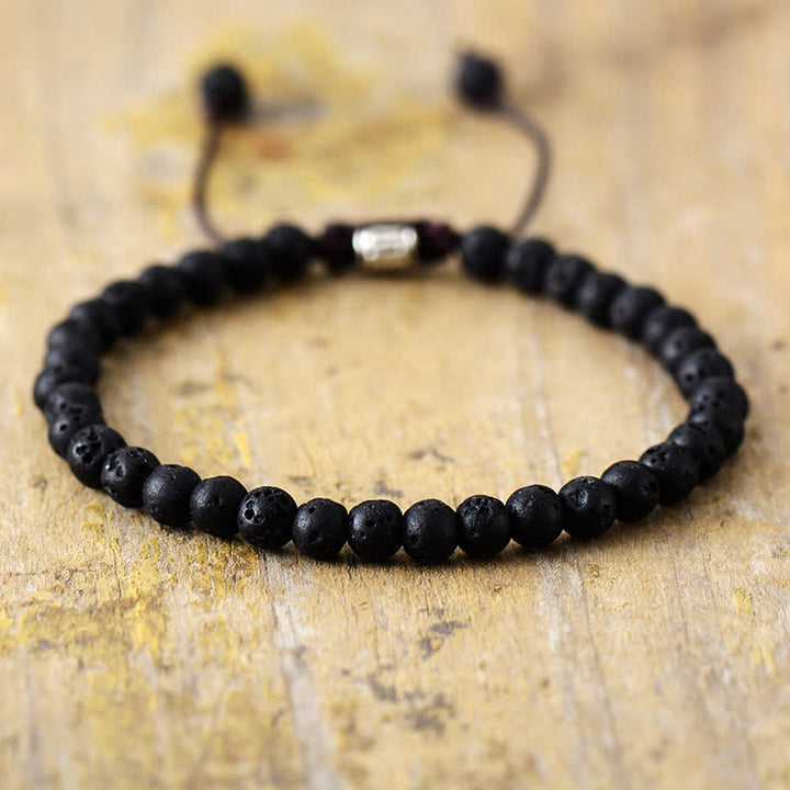 Schwarzes Lavastein-Armband, verstellbar, handgefertigt, auf Holzoberfläche.