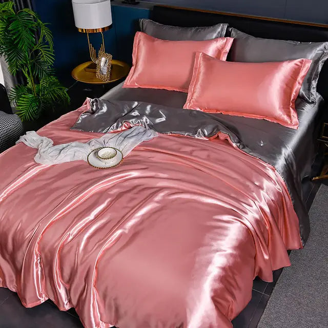 Luxuriöse rosa und graue Seidensatin-Bettwäsche-Set auf Doppelbett mit Kissen und Nachttischlampe.