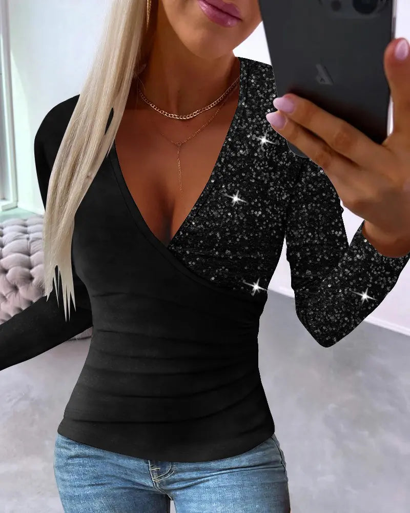 Frau in schwarzem Glitzer-Top mit Smartphone, Jeans, lange blonde Haare, modernes Outfit.