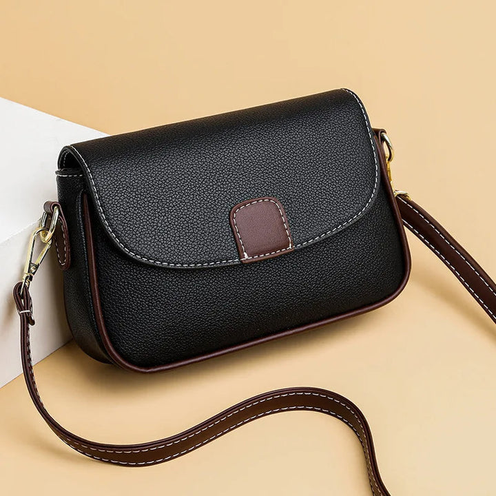 Schwarze Lederhandtasche mit braunen Akzenten, Umhängetasche, elegant, Damenmode.