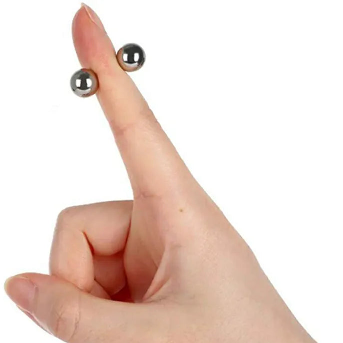Natažený ukazováček s dvěma malými stříbrnými kuličkami přichycenými magnetem z obou stran špičky prstu. 8