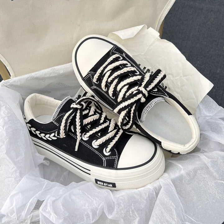 Schwarze Canvas-Sneaker mit weißen Schnürsenkeln und Blattmuster, Unisex, modisch, bequem.