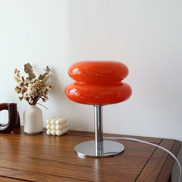 Orangefarbene Tischlampe aus Glas auf Holztisch, moderne Inneneinrichtung, Retro-Design.