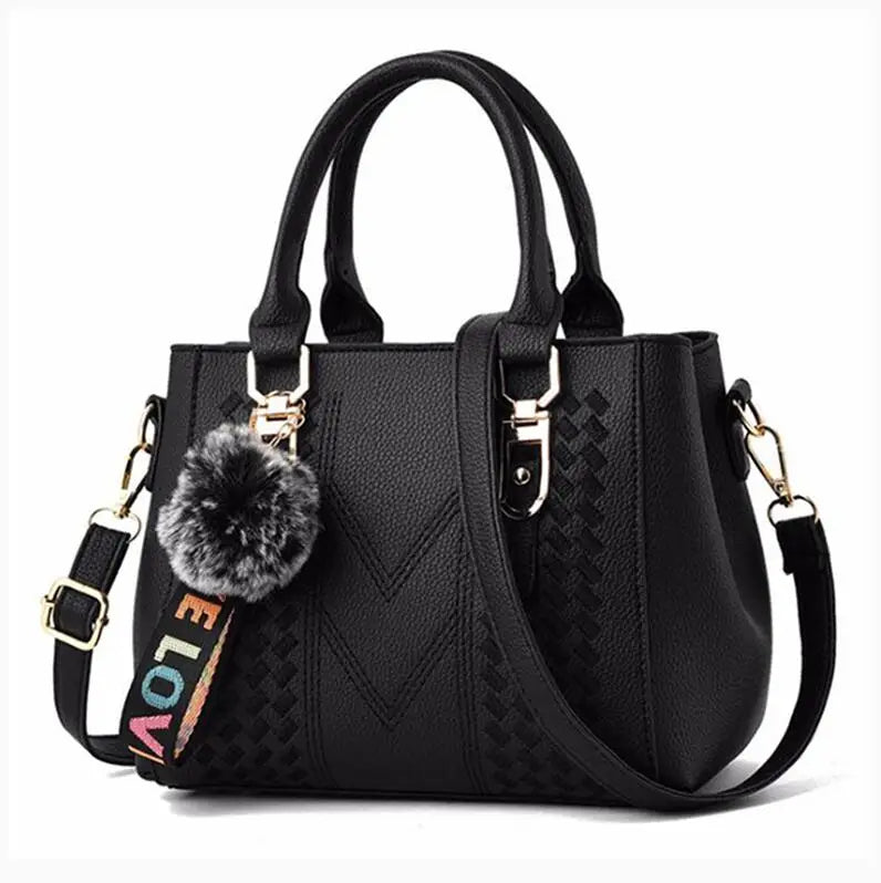 Schwarze Damenhandtasche mit Pompon-Anhänger, verstellbarem Riemen, Lederoptik.