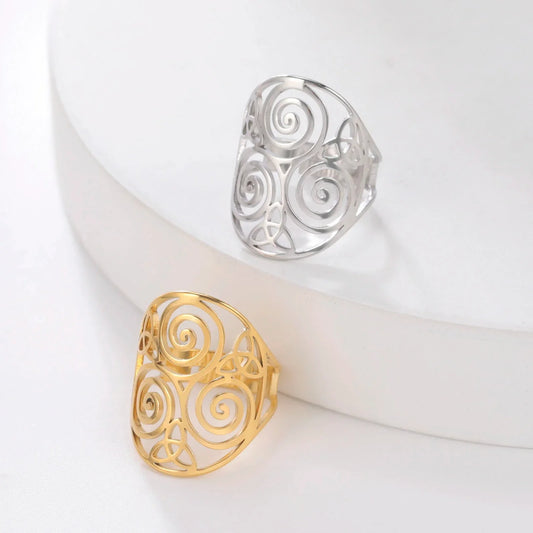 Zwei filigrane Ringe, gold und silber, mit Spiralmuster, Schmuckdesign, elegant, modern.